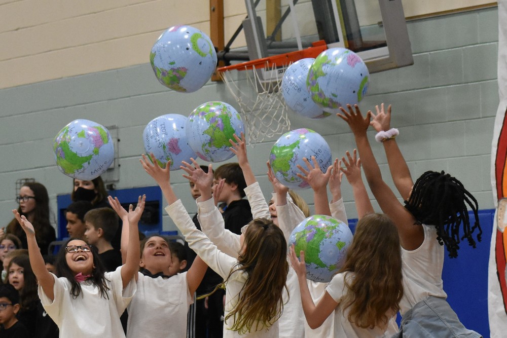 Evergreen students throwing blow-up globes joyfully in the air