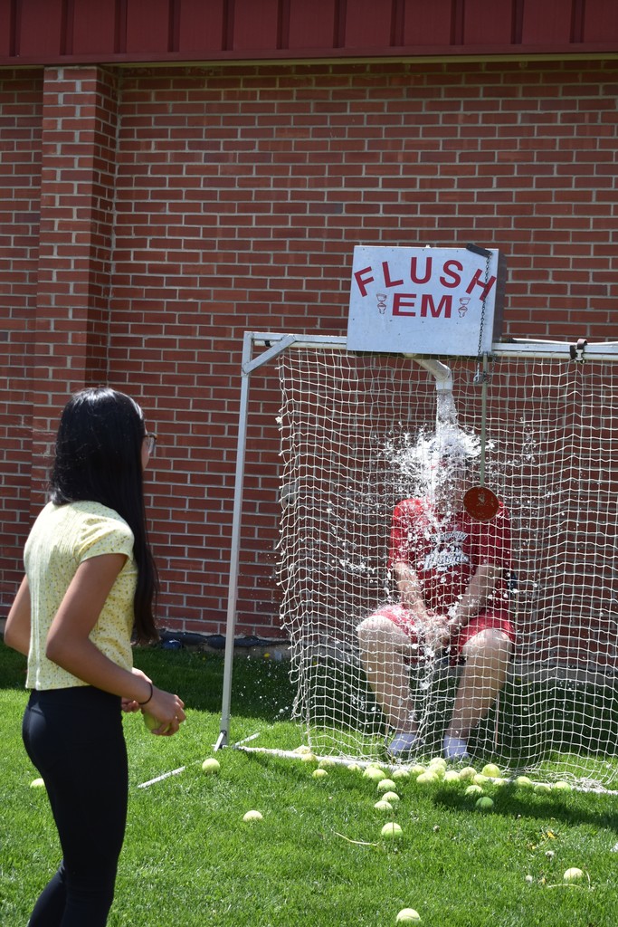Front view of Dr. Fitzgerald getting soaked by the reverse dunk talk while a student prepares for her next throw