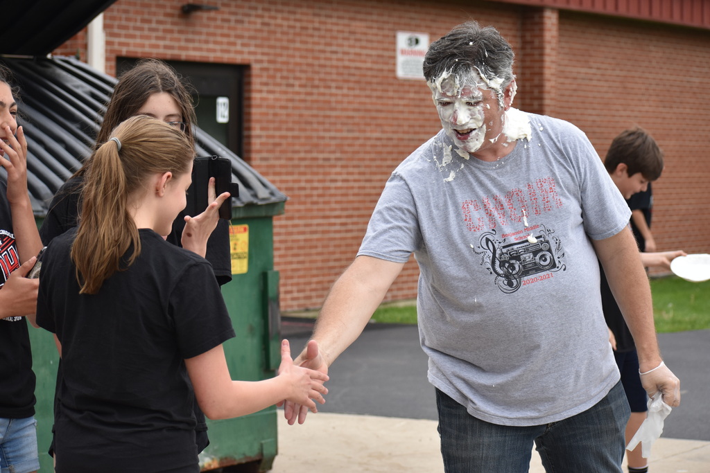 Dr. Fitzgerald shaking the hand of a student who just threw pie in his face