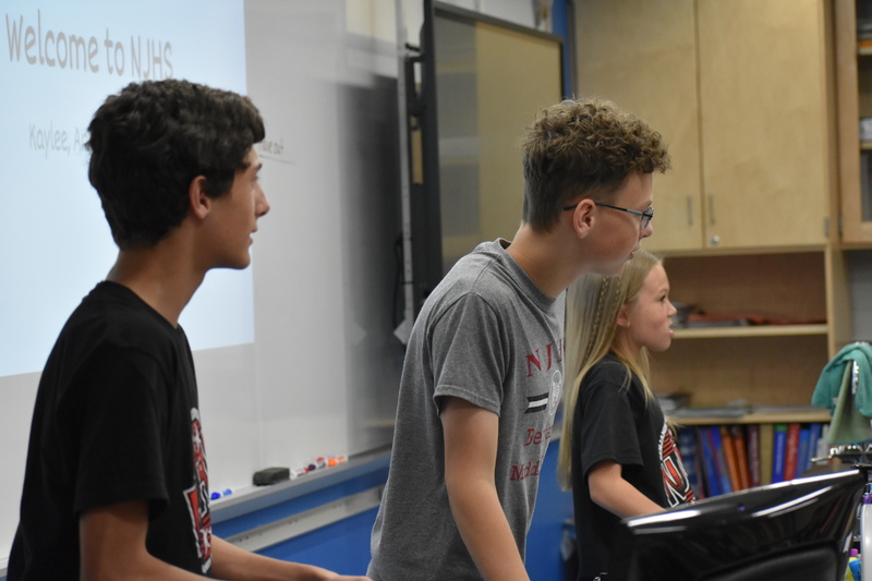 Three students lead a classroom activity as a part of Charity Fest